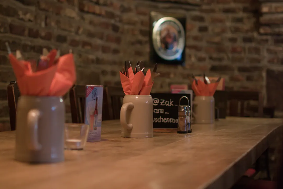 Gedeckter Tisch vor der Backsteinwand am Abend